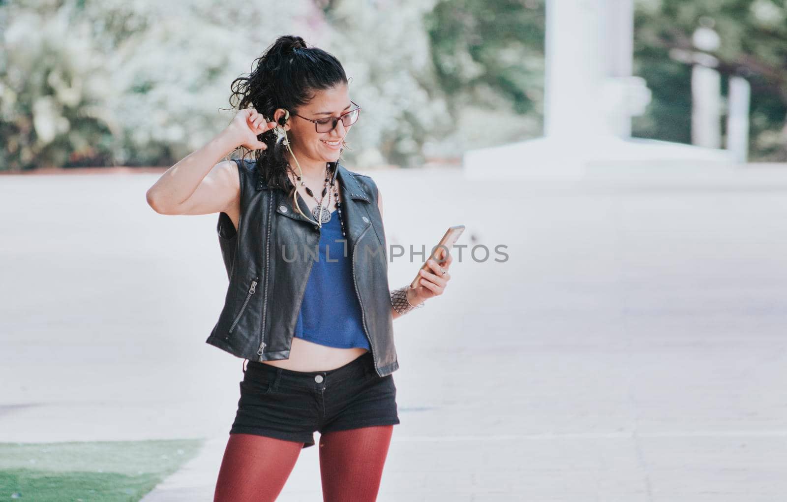 Latin girl listening to music outdoors, Urban girl listening to music with headphones outdoors, Happy woman listening to music outdoors
