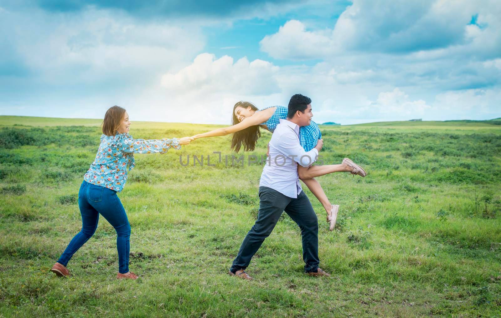 Boyfriend carrying his girlfriend on his back, three friends playing in the field, Friendship concept