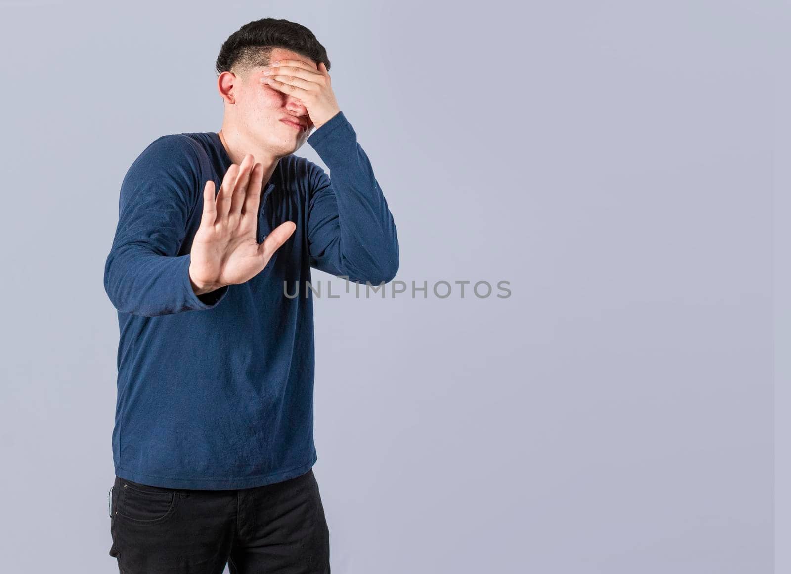 Scared confused man closing eyes with palm of hand, Scared man closing his eyes with the palm of his hand, Concept of man covering his eyes with the palm of his hand