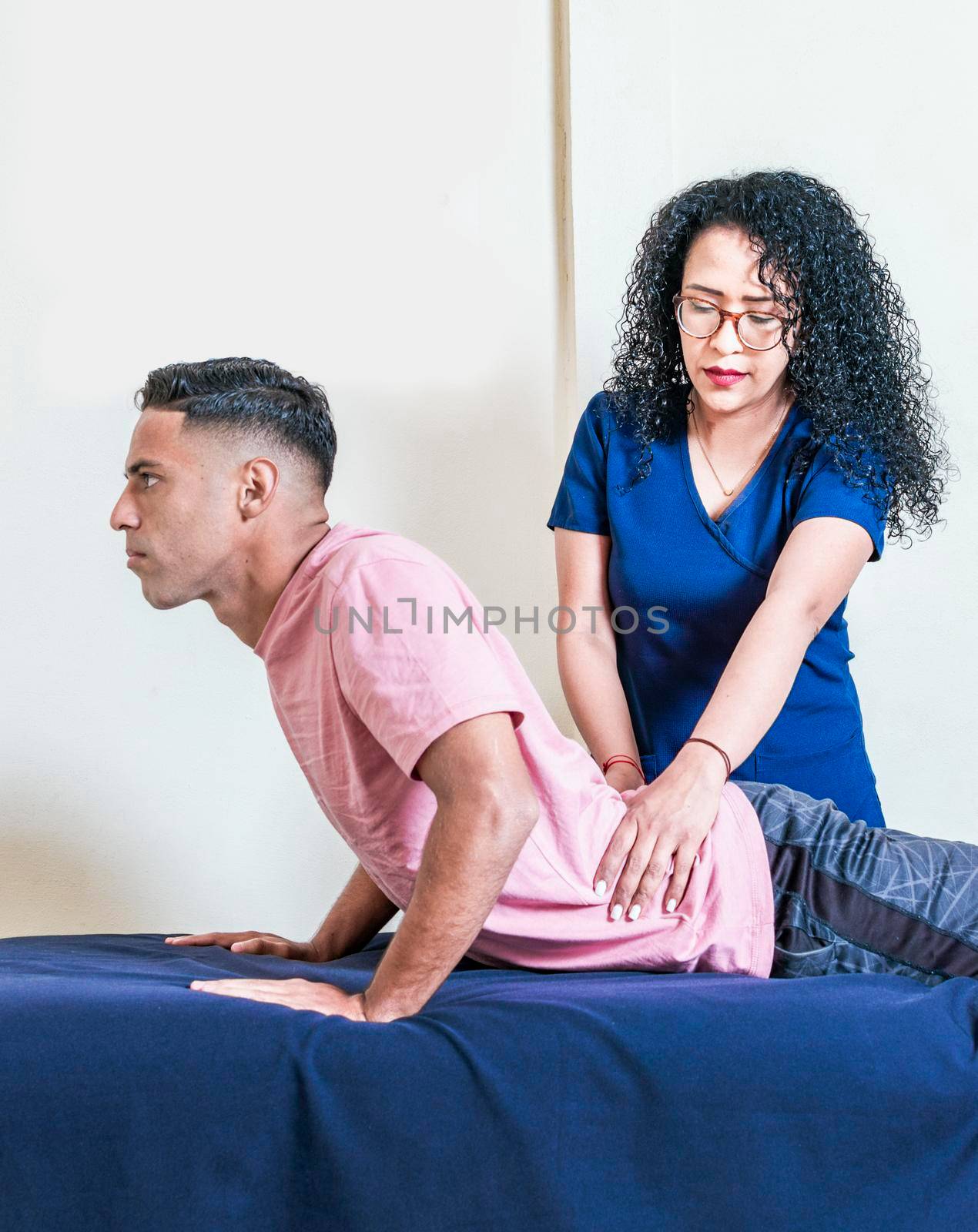 Lower back physiotherapy, physiotherapy treatment concept, physiotherapist with patient by isaiphoto