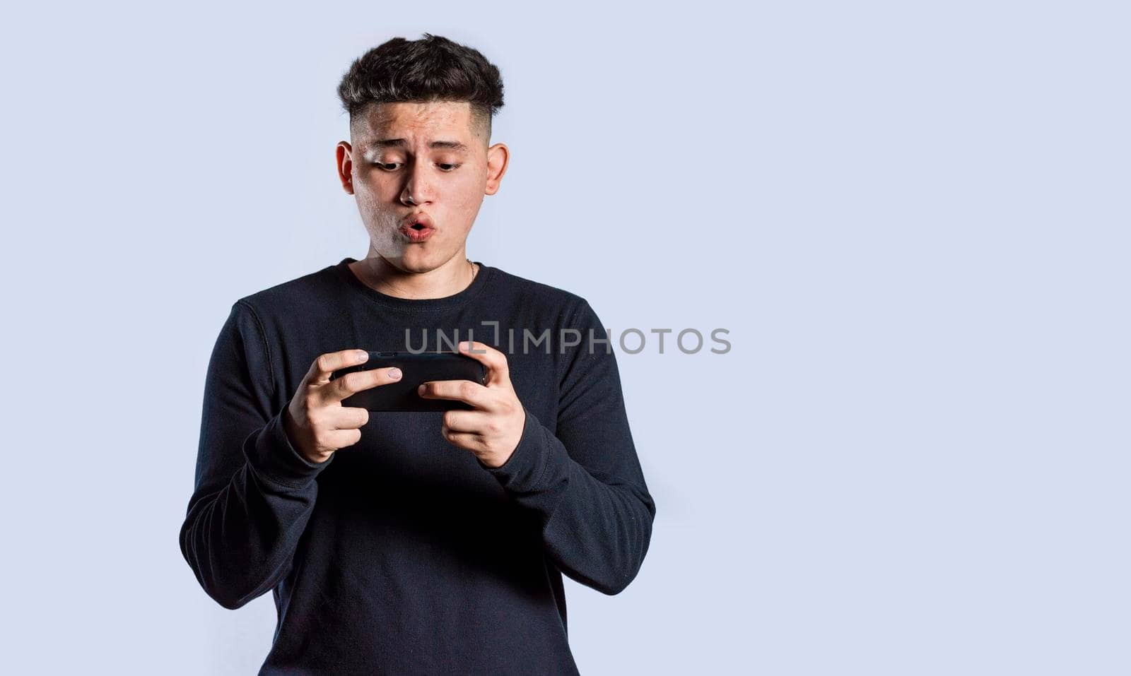 Man holding cell phone horizontally, Guy gasping and playing games on his smartphone