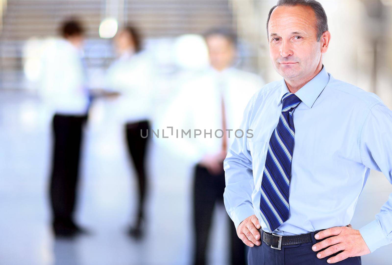 Happy mature business man looking at camera with satisfaction at office