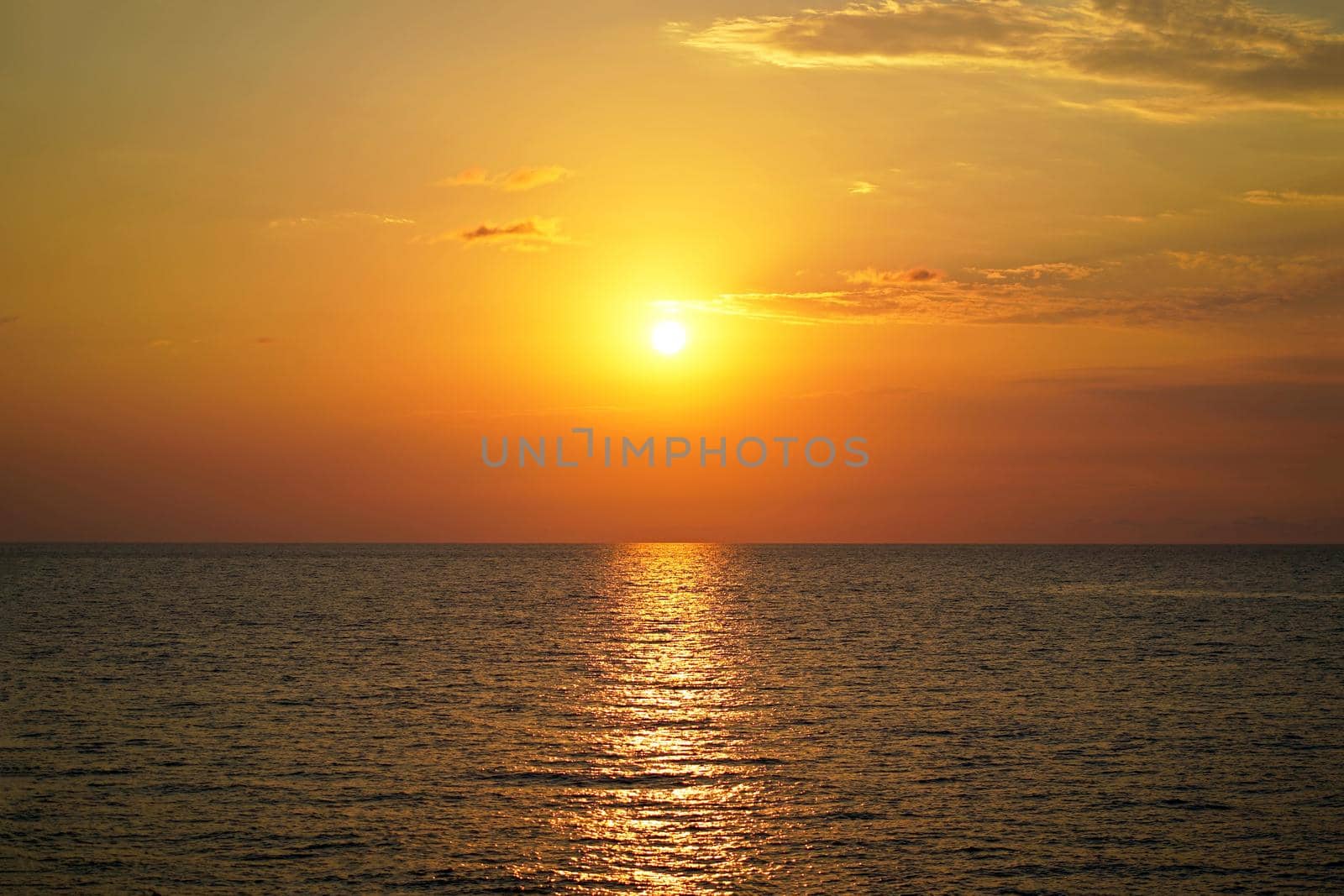 Beautiful colorful sunset at the sea with dramatic clouds and sun shining. Beauty world natural outdoors travel background.