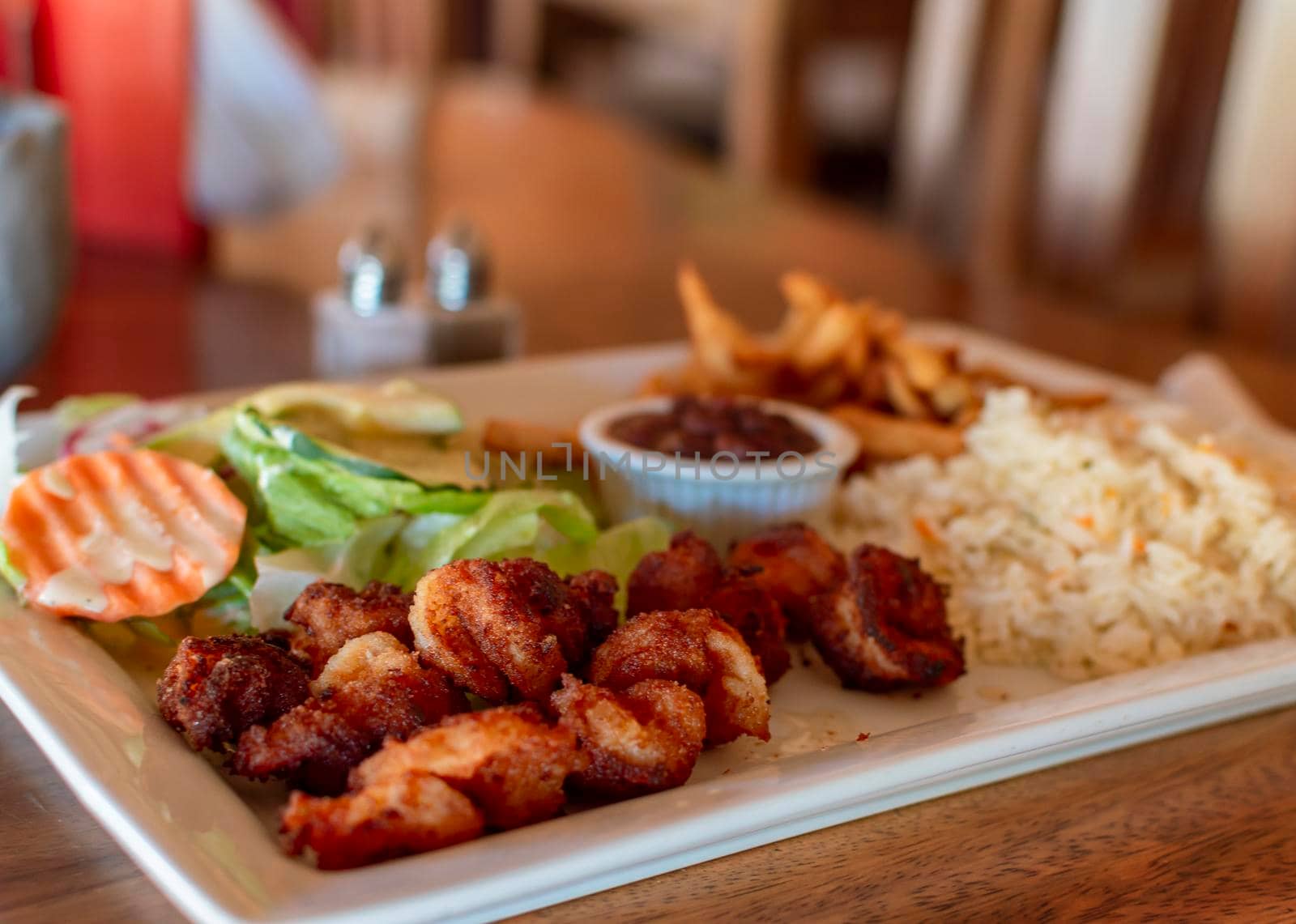 Plate of breaded shrimp with rice on the table with COPY SPACE, menu of breaded shrimp served on wooden table