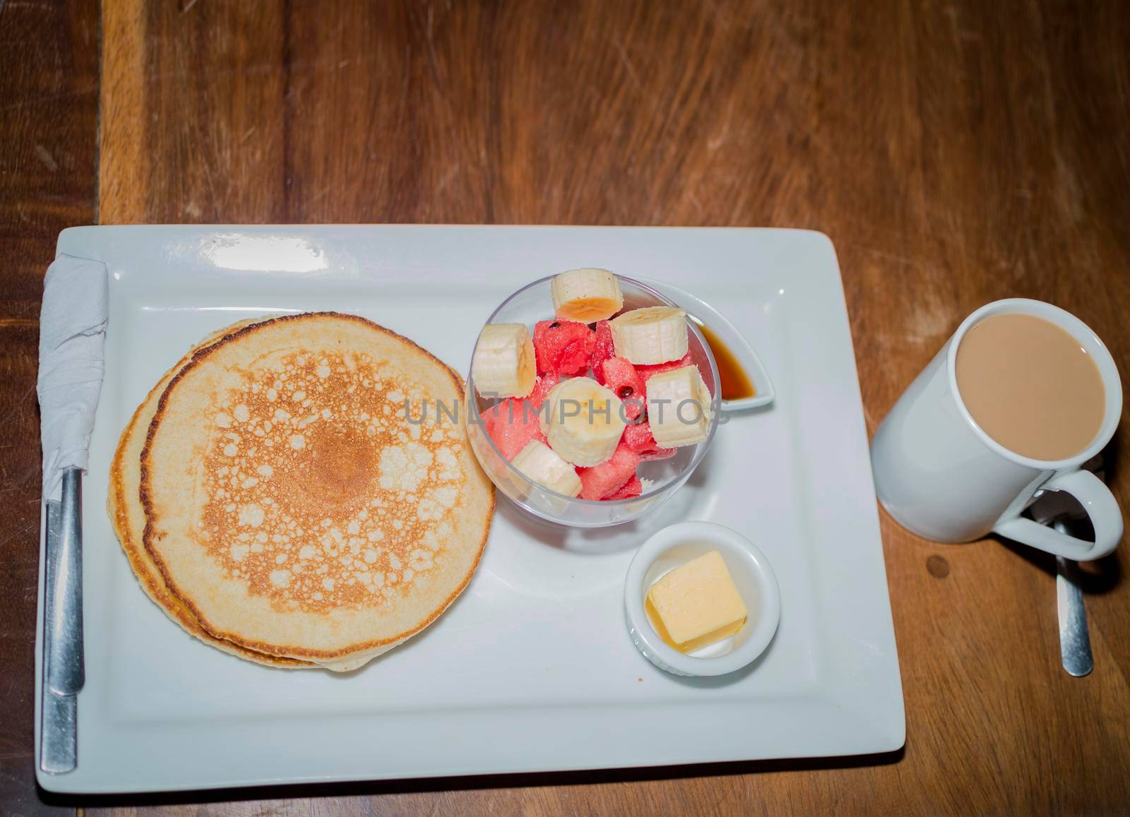 Omelet breakfast with fruit salad served on a wooden table, healthy breakfast concept with COPY SPACE