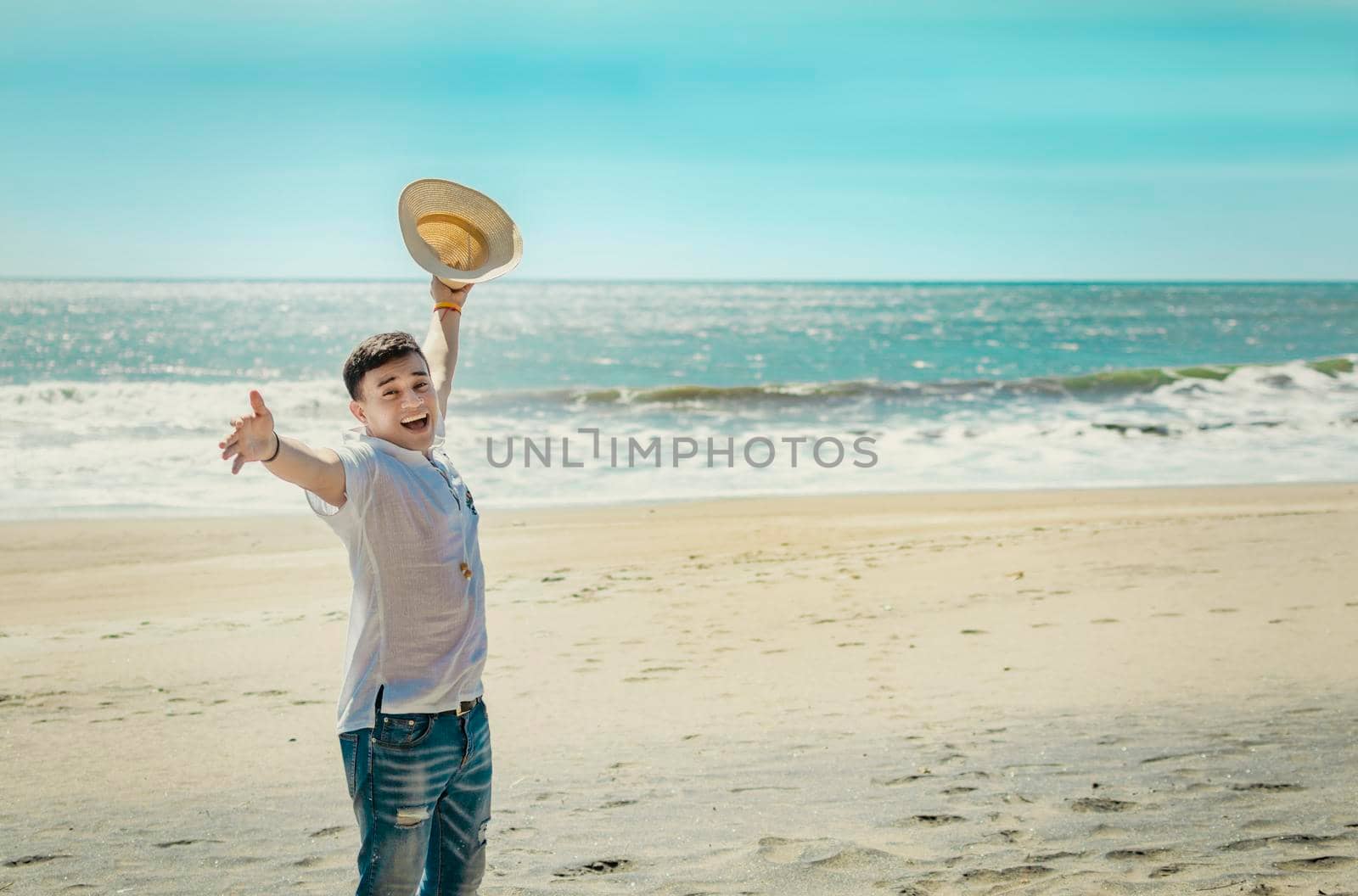 Happy handsome man on vacation outdoors, Happy latin young man on the beach, Tourist travel concept