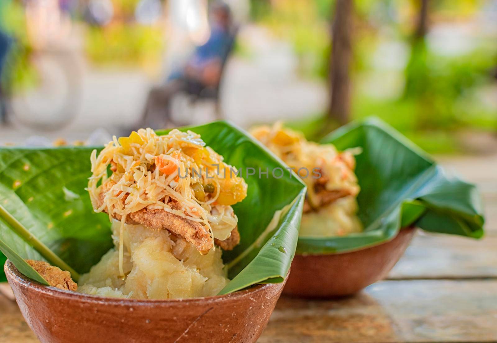 Vigorón with leaves served on a wooden table, two vigorones served on wooden background, vigorón typical food from nicaragua