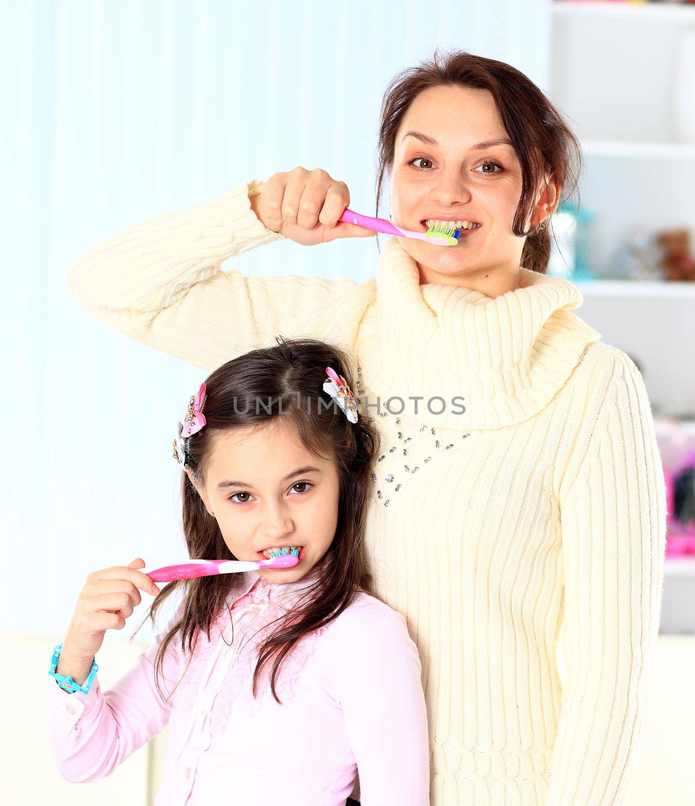 Mother and daughter brush their teeth. by SmartPhotoLab