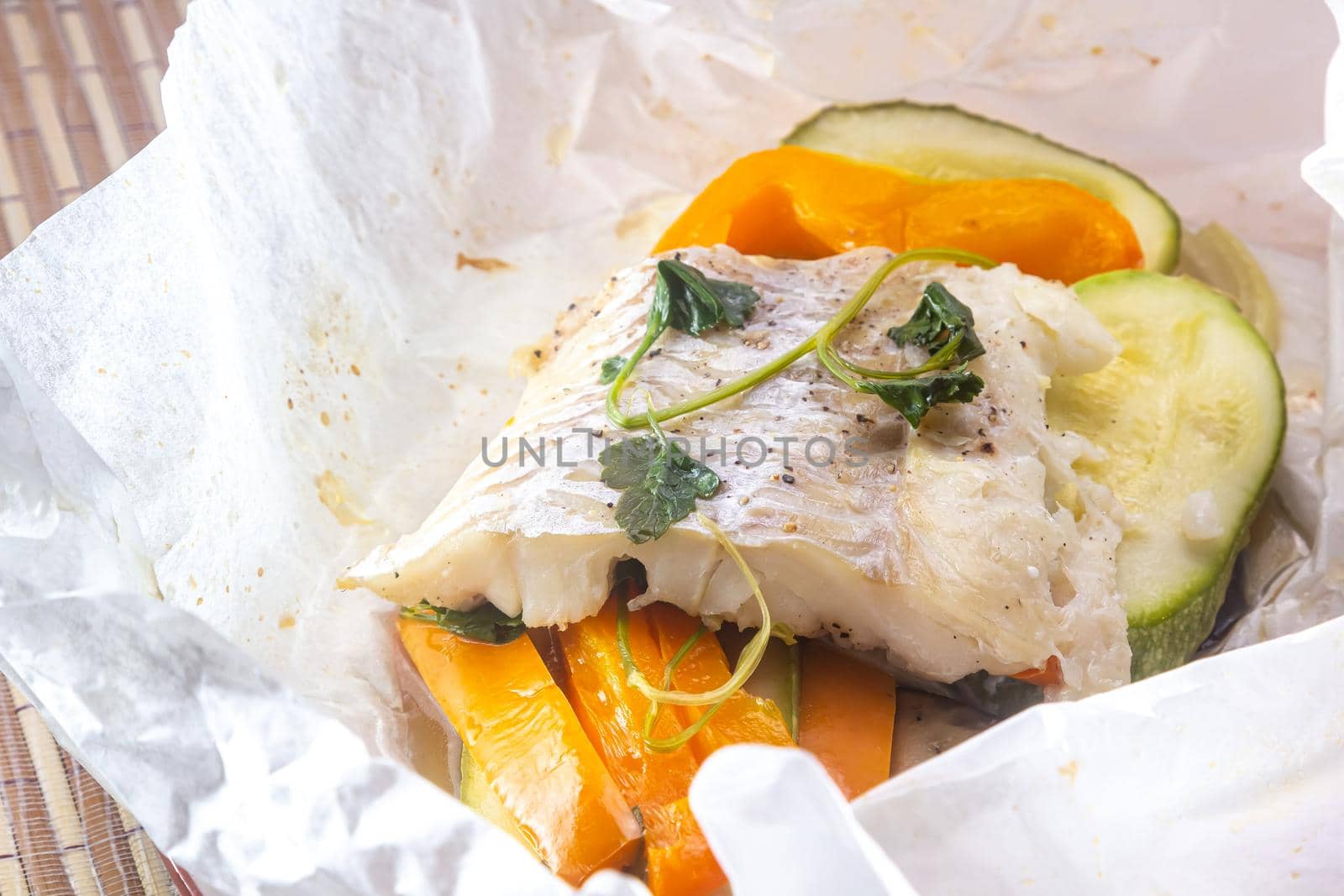 White fish fillet with vegetables in rustic style. Healthy eating: cooked fish fillet with vegetables garnish. Diet food with white fish and vegetables. Steam vegetables with roasted zander fillet.
