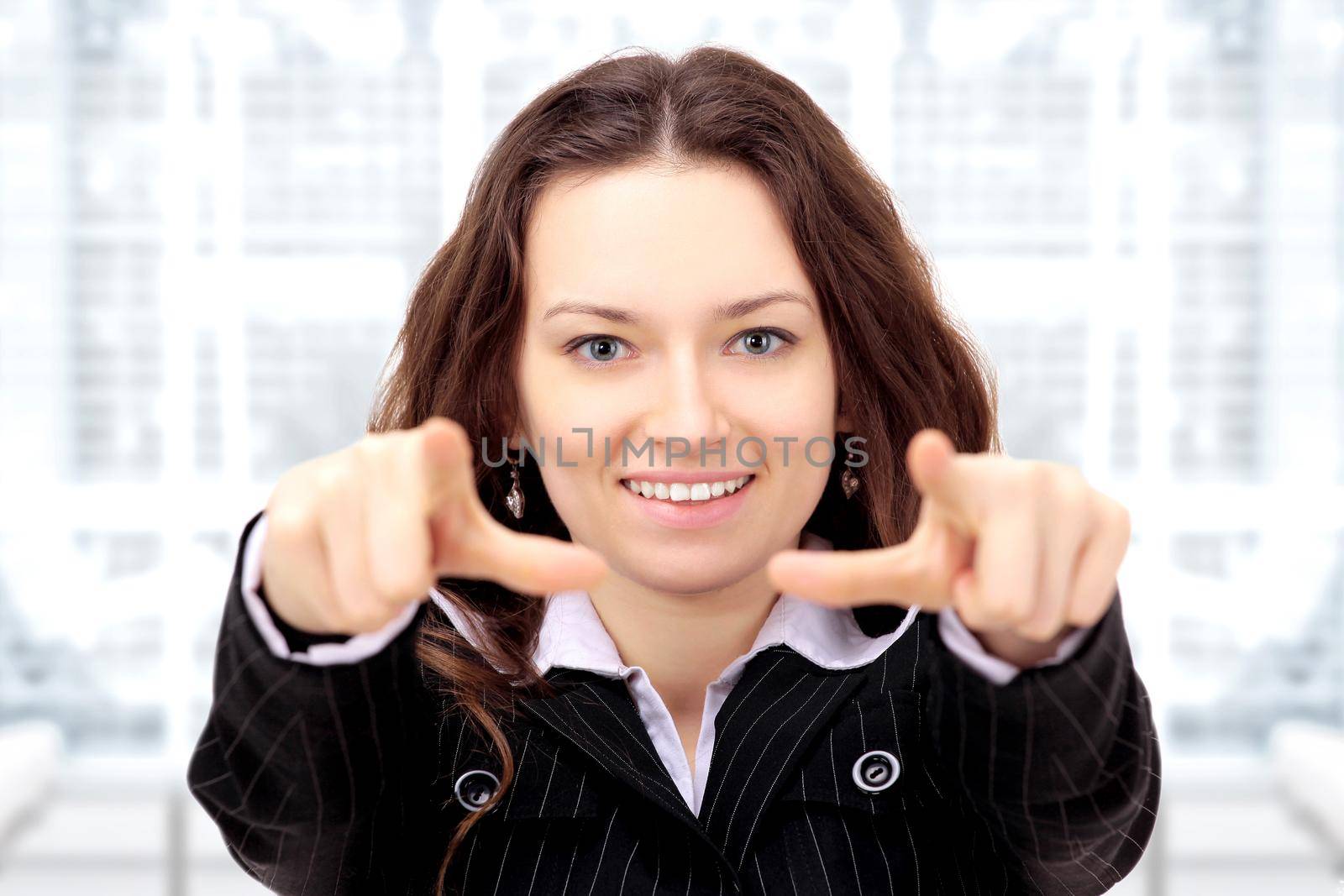 Beautiful businesswoman shows a forward index fingers in the office.