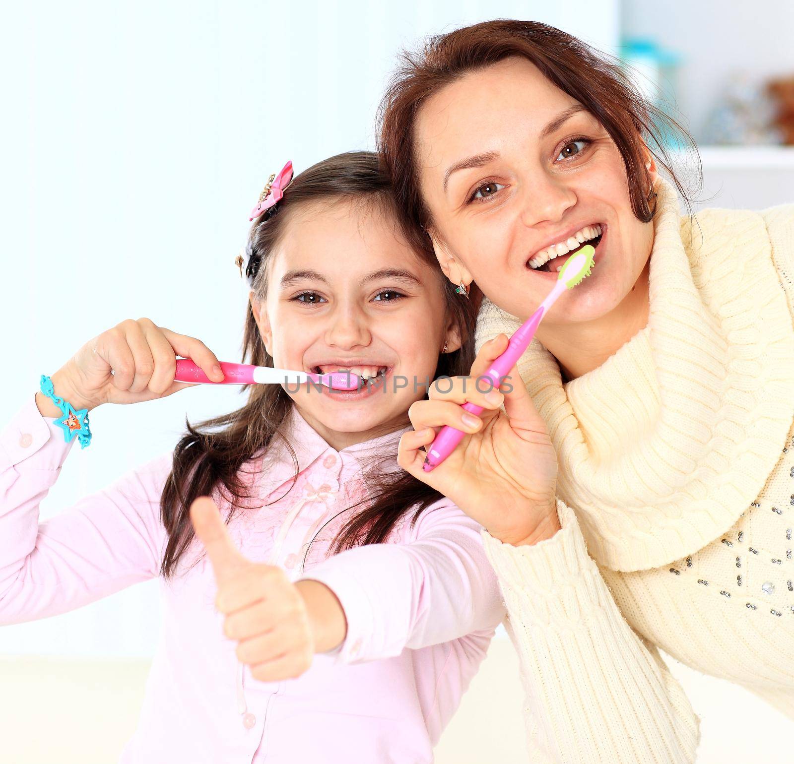 Mother and daughter brush their teeth. by SmartPhotoLab