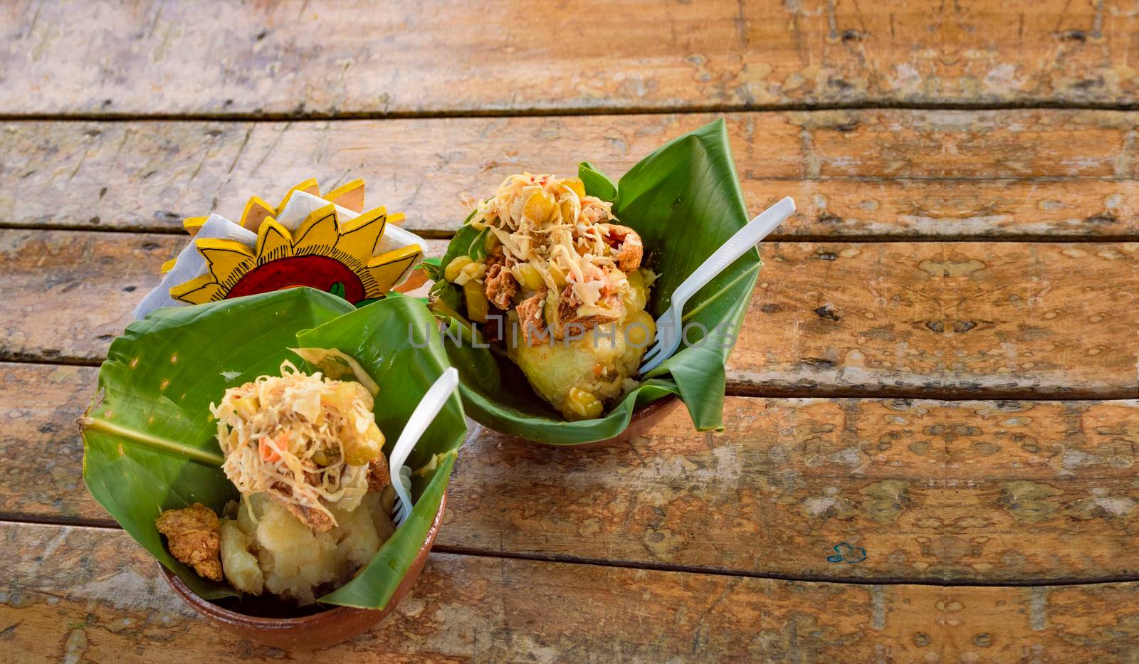 Vigorón with leaves served on a wooden table, two vigorones served on wooden background, vigorón typical food from nicaragua