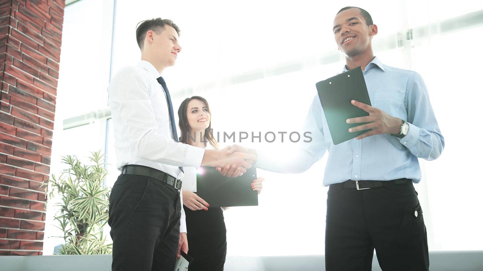 handshake of business partners standing in the office.the business concept