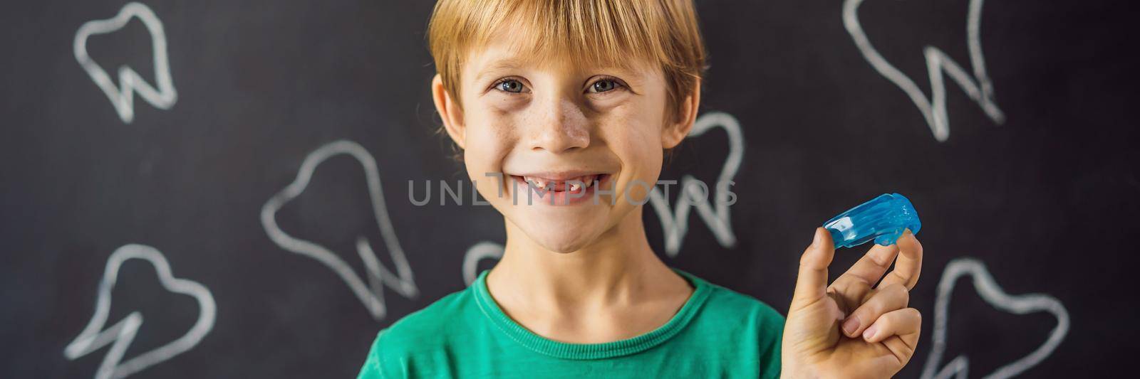 BANNER, LONG FORMAT Six-year old boy shows myofunctional trainer. Helps equalize the growing teeth and correct bite, develop mouth breathing habit. Corrects the position of the tongue by galitskaya