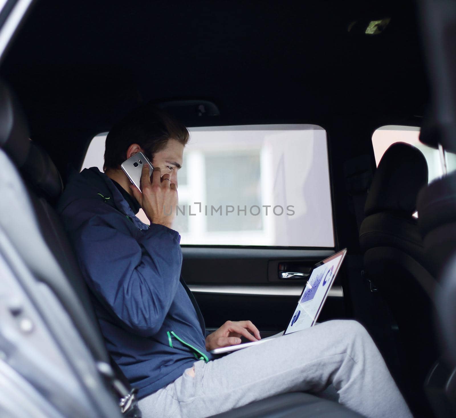 closeup. business man uses a laptop and mobile phone sitting in the car