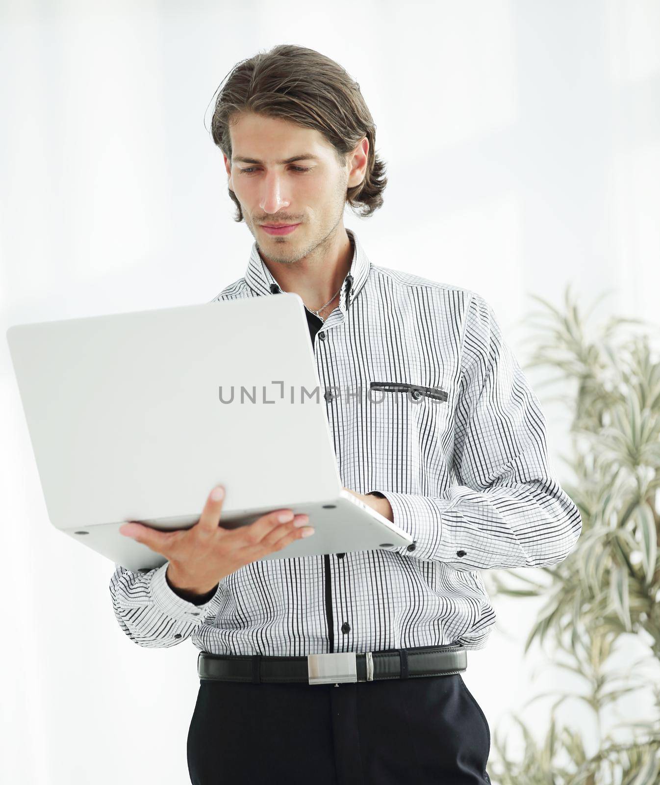 closeup.serious businessman working on laptop standing in office.