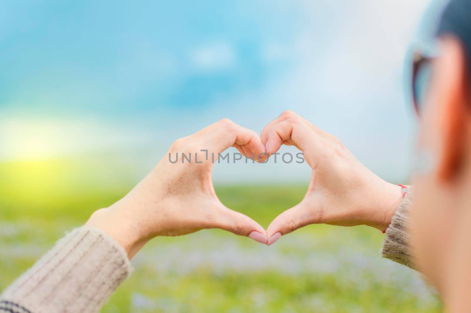 Hands together in a heart shape, woman's hands together in a heart shape, hands making a heart shape