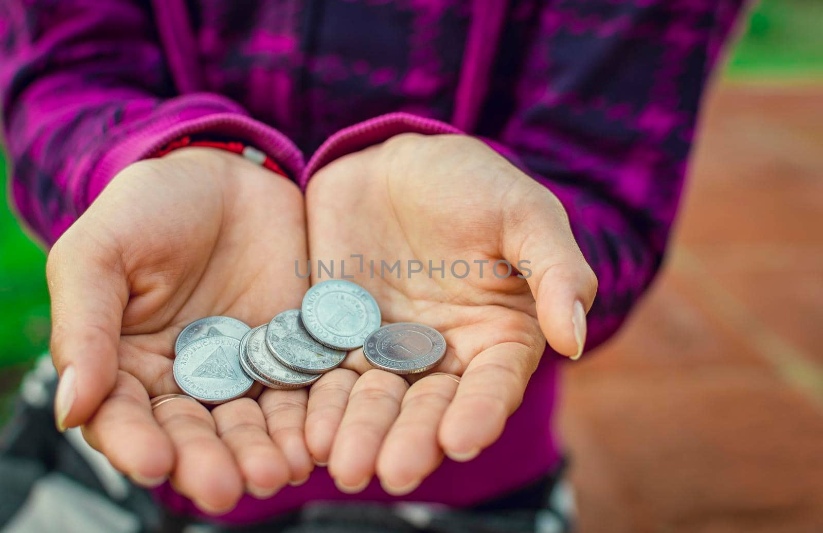 Close up of coins in hands, Nicaraguan coins in hands, savings concept by isaiphoto