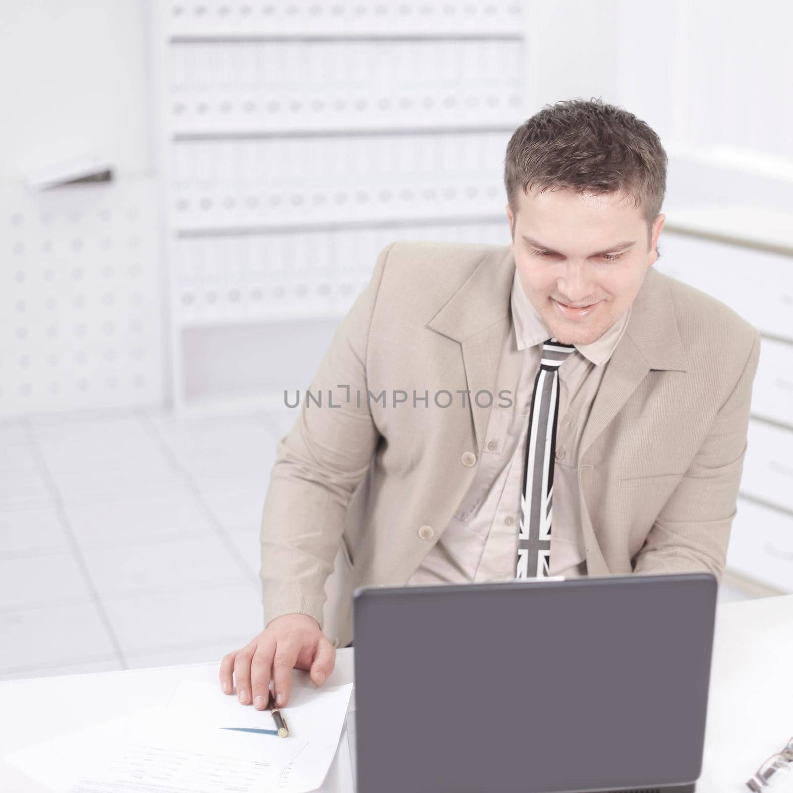 employee of the company working on laptop in the office. by SmartPhotoLab