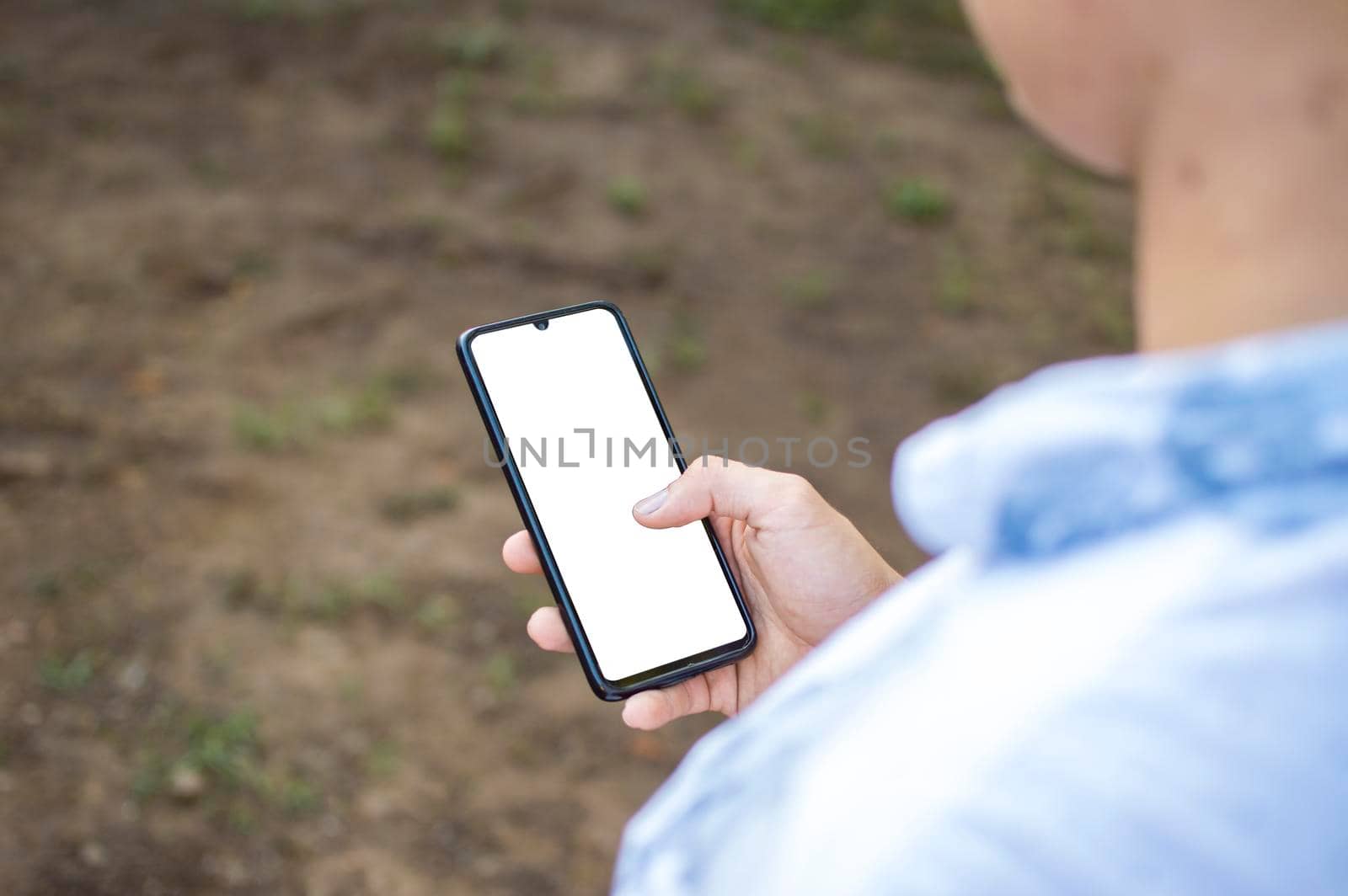 Close up of a man with cell phone in hand, close up shot of a person checking his cell phone, young guy with cell phone in hand with copy space