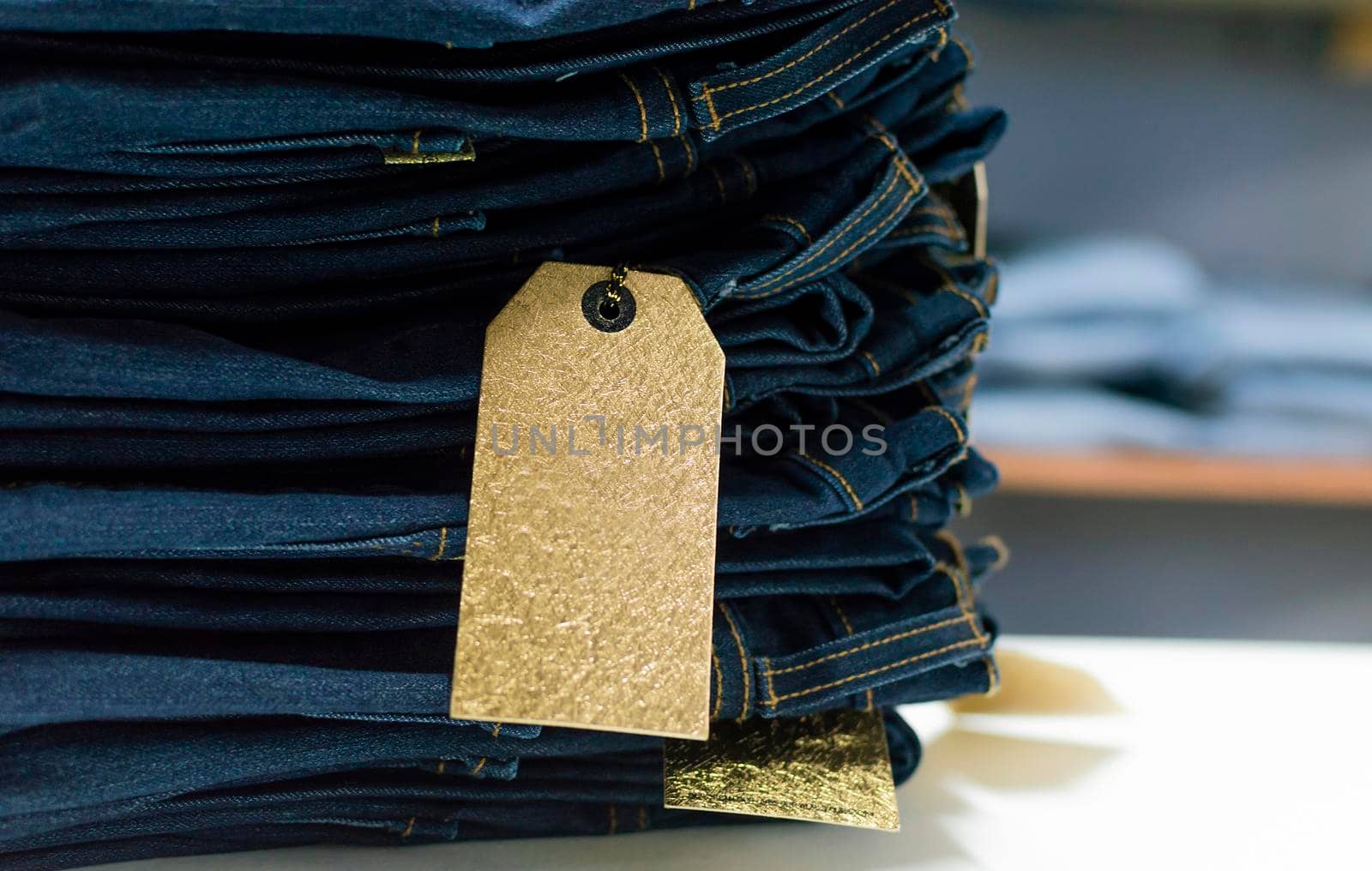 Close up of blue jeans on others with copy space; Various jeans on others with space for text; Clothes sale concept