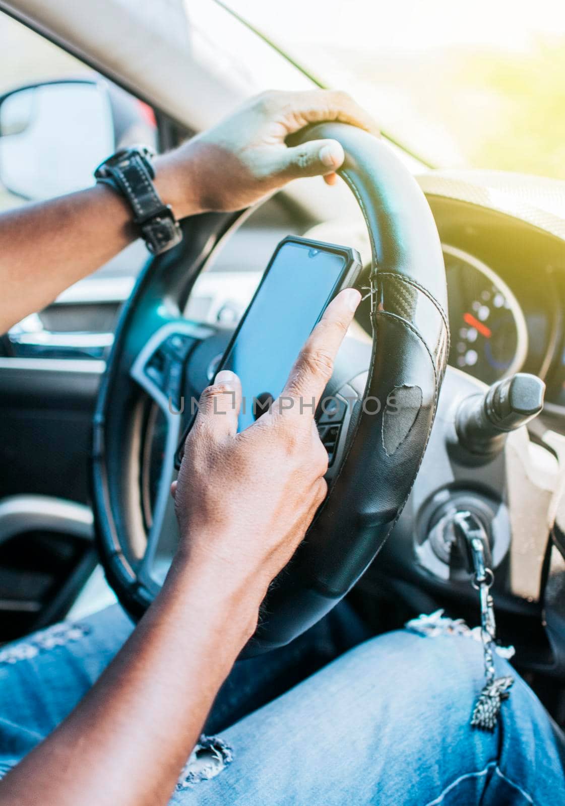Close up of driver hands using his phone, Concept driver hands touching cell phone screen, Person in his car using cell phone by isaiphoto