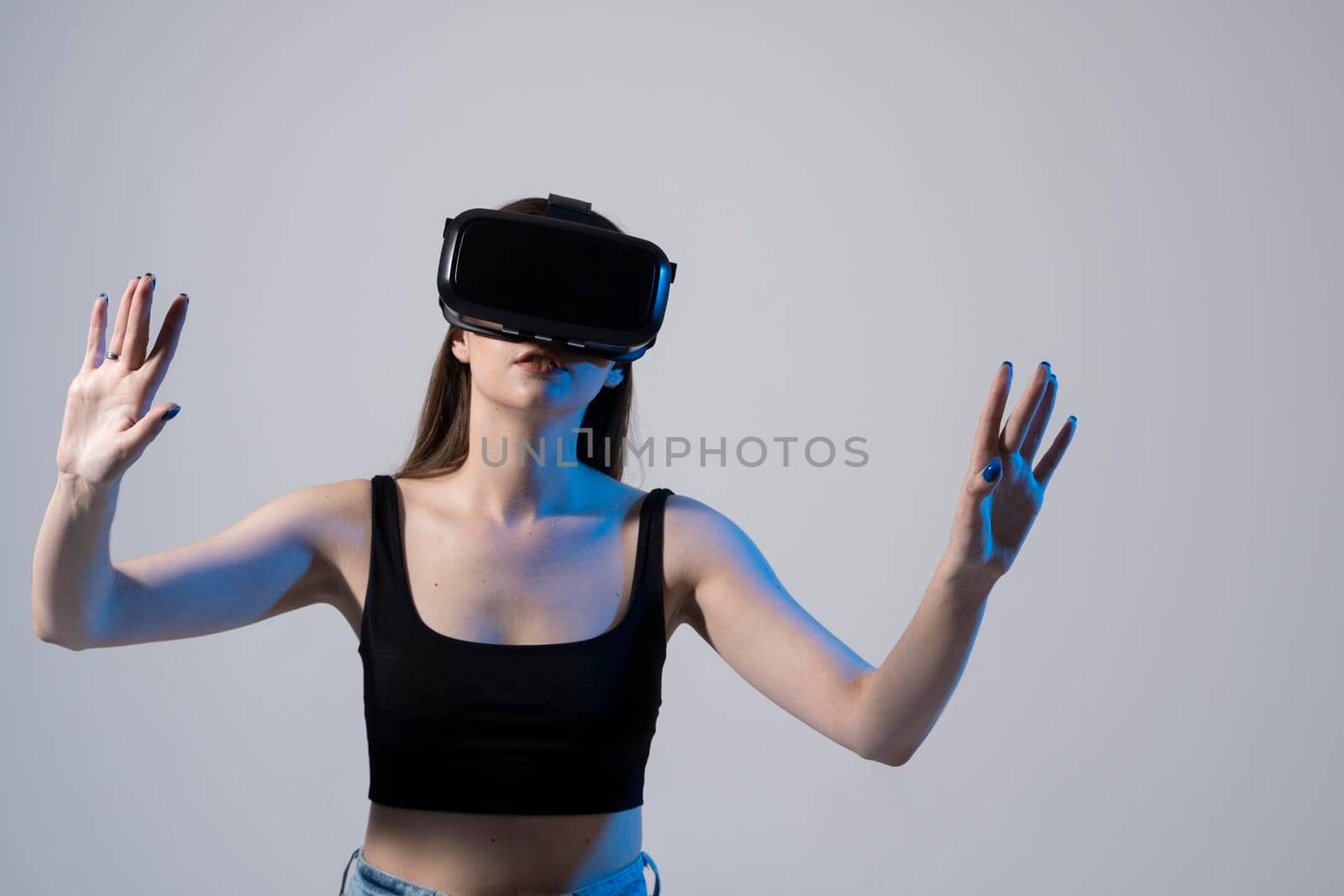 Amazed happy brunette girl in black t-shirt getting experience using VR headset glasses of virtual reality and exploring a new cyber worlds. by vovsht