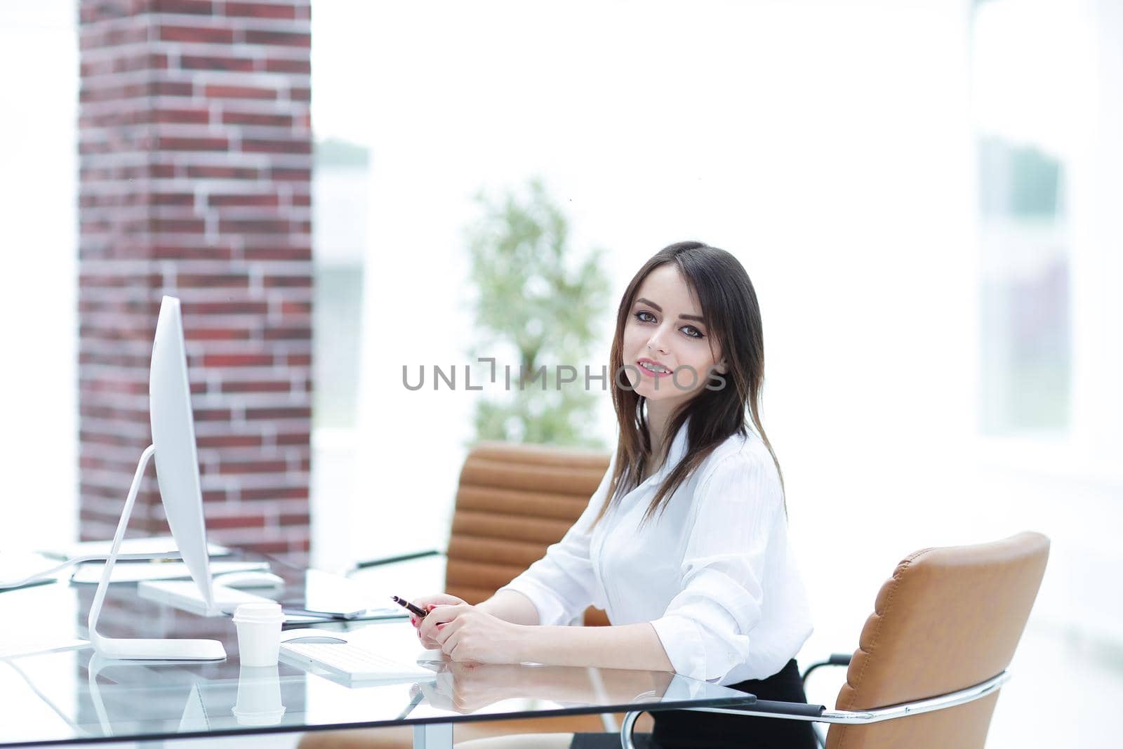 confident business woman sitting behind a Desk.photo with copy space
