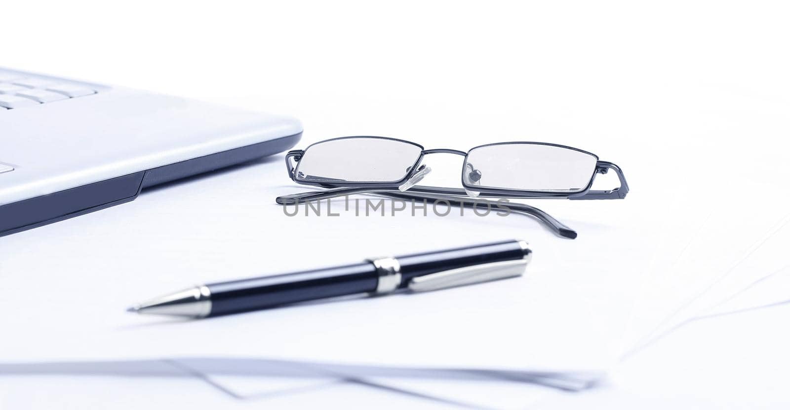 notebook ,glasses and pen on the workplace of the businessman .isolated on a white