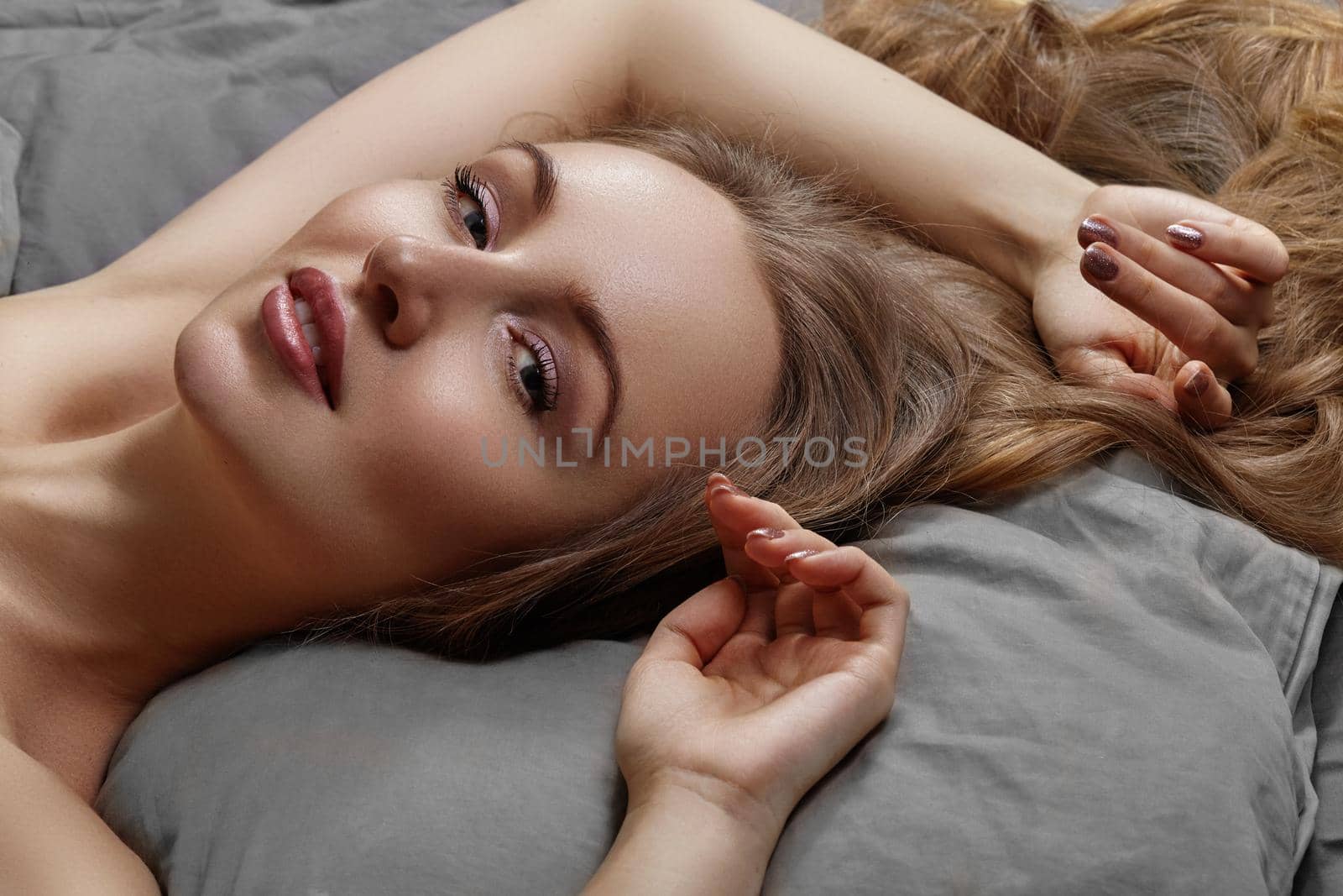 Beautiful Woman Sleeping while lying in Bed with Comfort. Sweet dreams. Sexy model relaxing on grey sheets by MarinaFrost