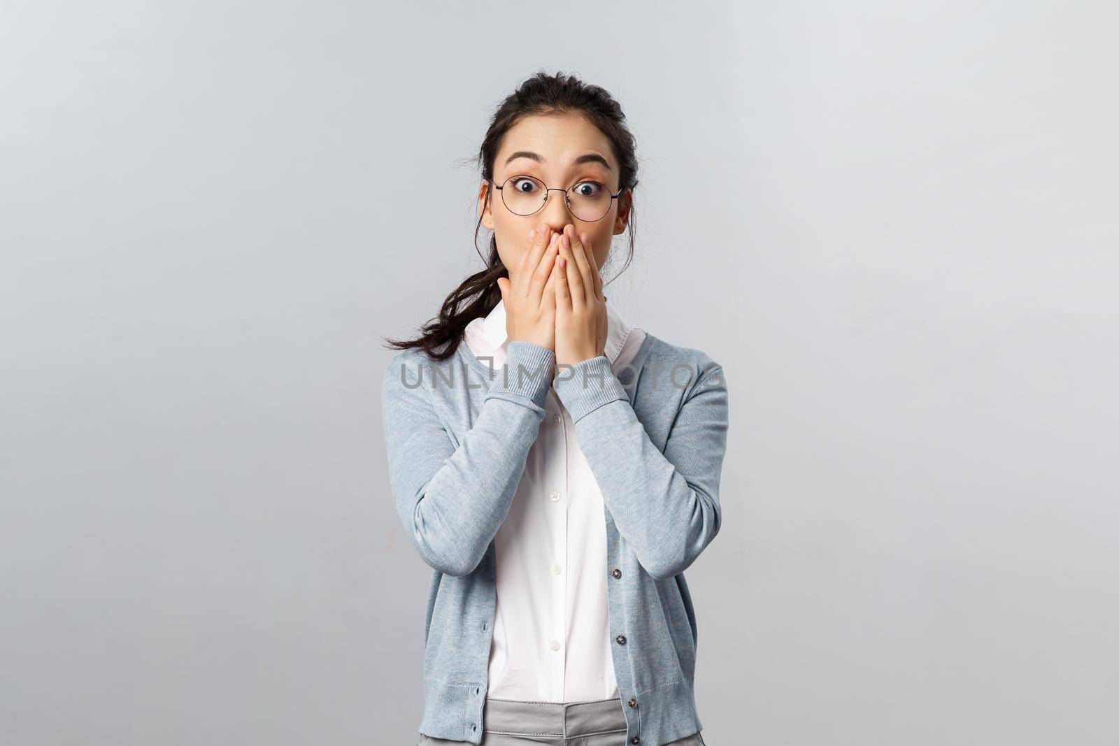 Shocked, speechless attractive asian woman gasping and cover mouth in awe, standing startled over grey background, listening to big shocking news, react impressed at gossip by Benzoix