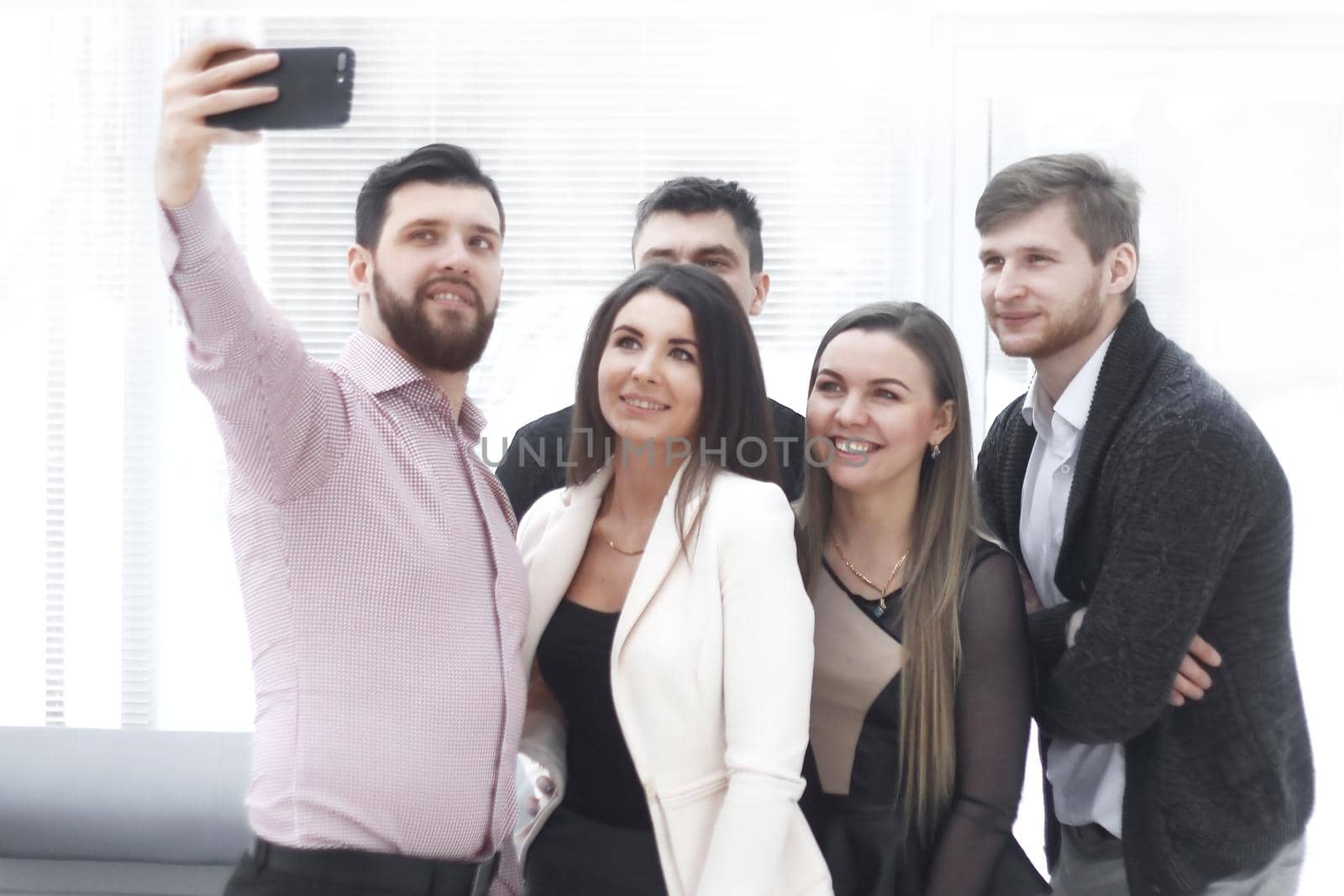 business colleagues taking a selfie in a modern office.