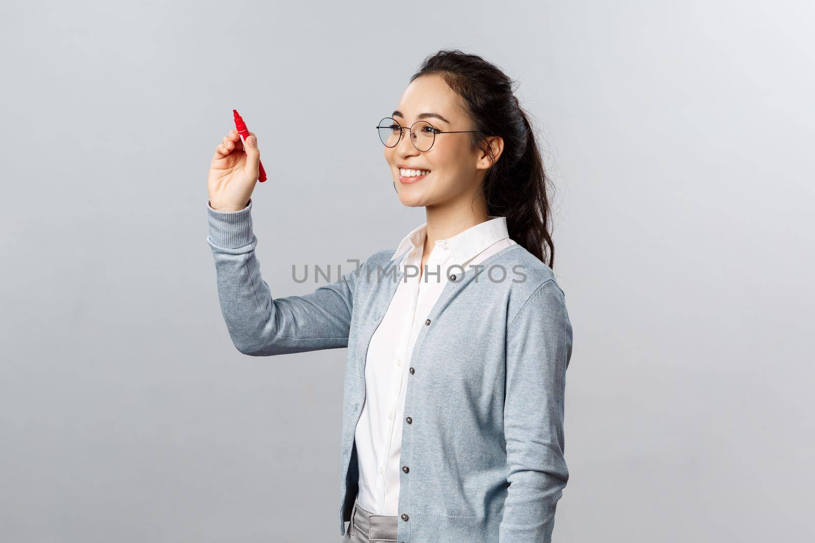 Teaching, online education and lifestyle concept. Young smiling smart student, tutor explain lesson material, solving exercise over blackboard, writing with red marker in air by Benzoix