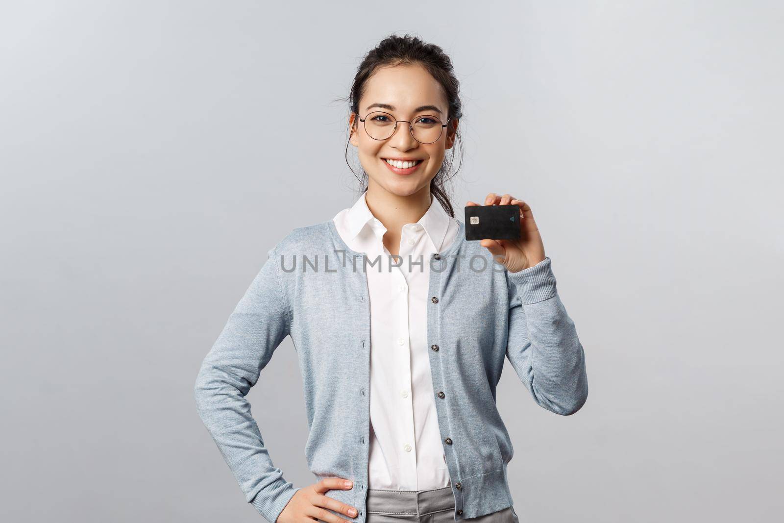 Technology, online purchases and finance concept. Cheerful, friendly-looking young asian woman recommend bank, using credit card to pay for delivery or shopping in internet during lockdown by Benzoix