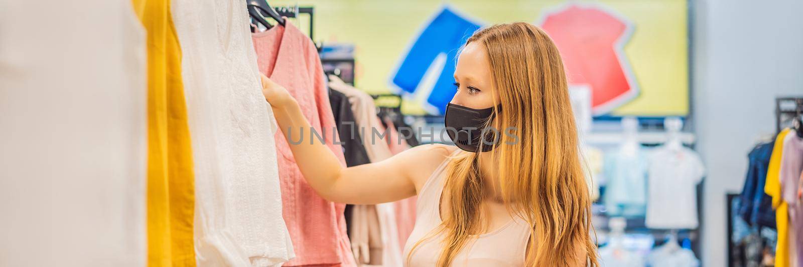 Woman in a clothing store in a medical mask because of a coronovirus. Quarantine is over, now you can go to the clothing store BANNER, LONG FORMAT by galitskaya