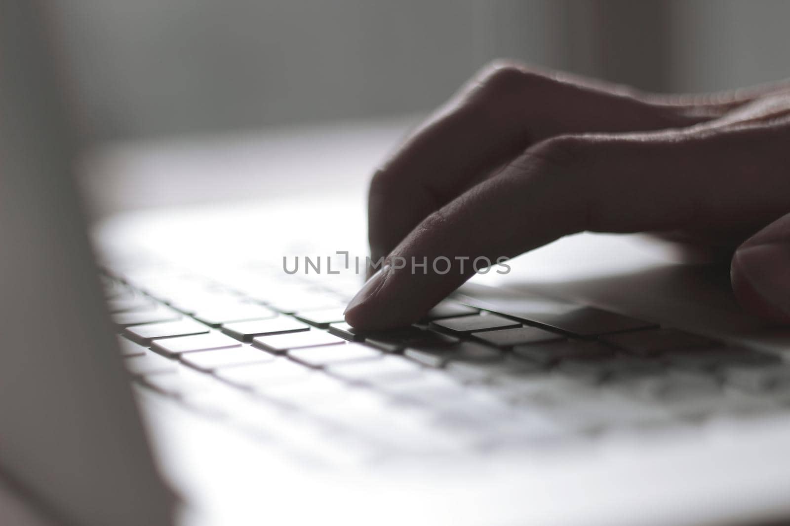 close up. blurred image of male hand typing on laptop keyboard.