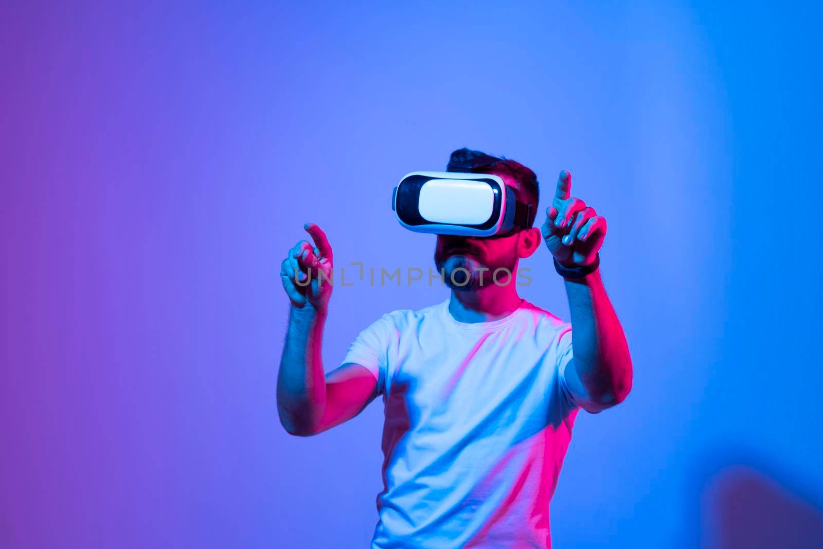 Modern architect, designer using virtual reality glasses at workplace. Designer working in augmented reality vr studio. Man working in VR goggles on a studio background. by vovsht