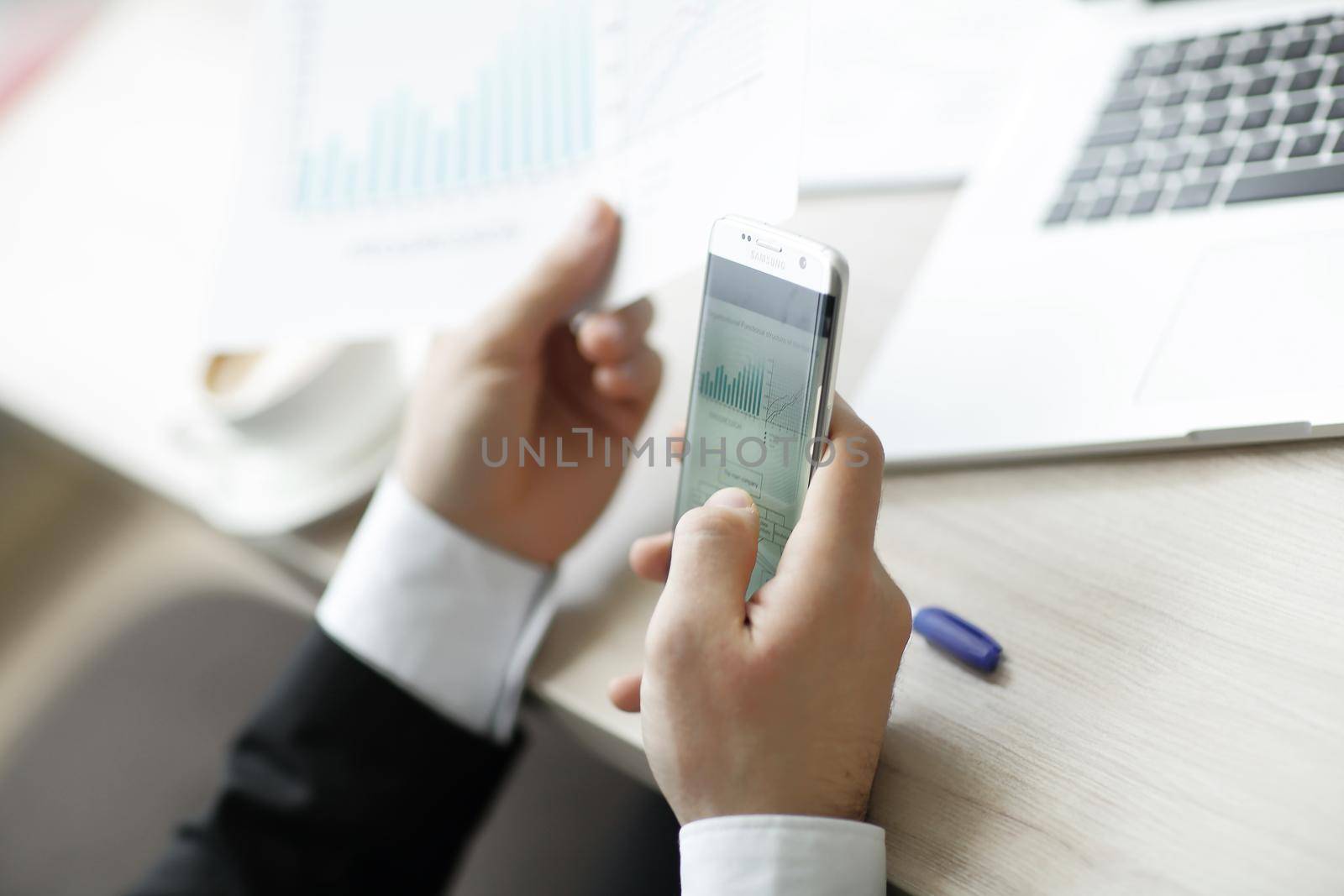 closeup.businessman checks the financial data using a smartphone.the business concept