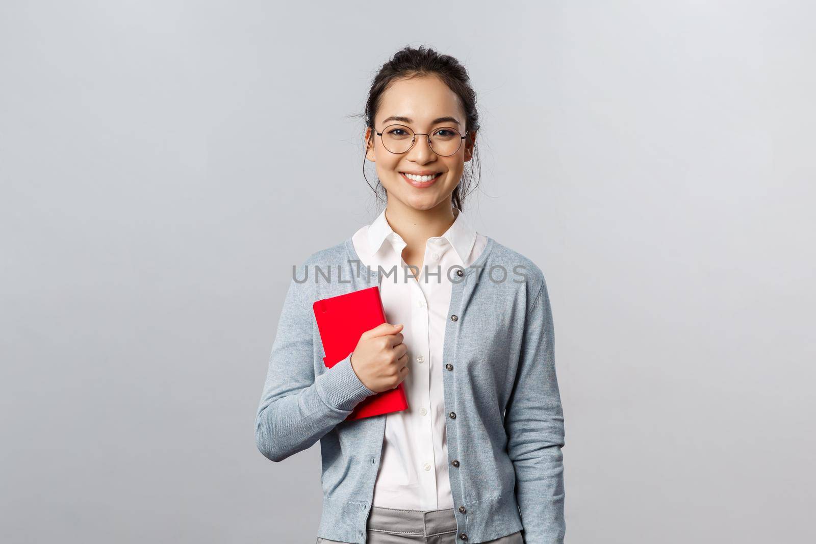Teaching, education and university lifestyle concept. Good-looking smart young asian female teacher, tutor or student holding red notebook, prepare for lesson, writing down notes in planner by Benzoix