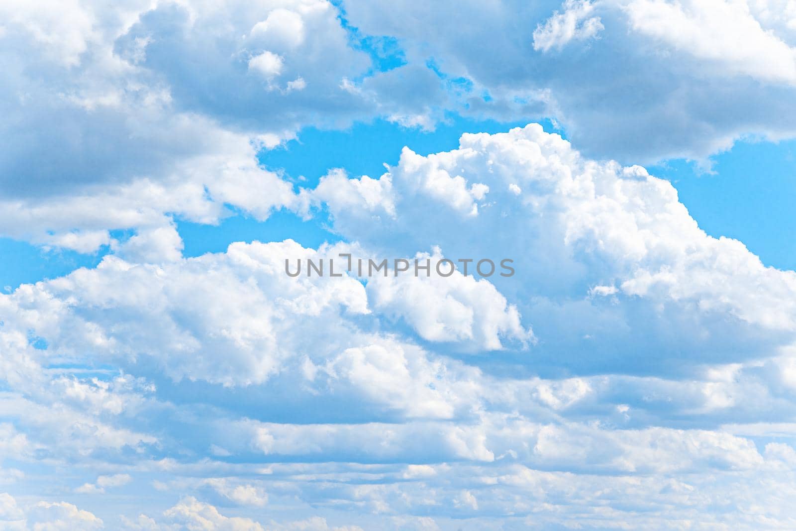 White cumulus clouds on bright blue sky by kisika