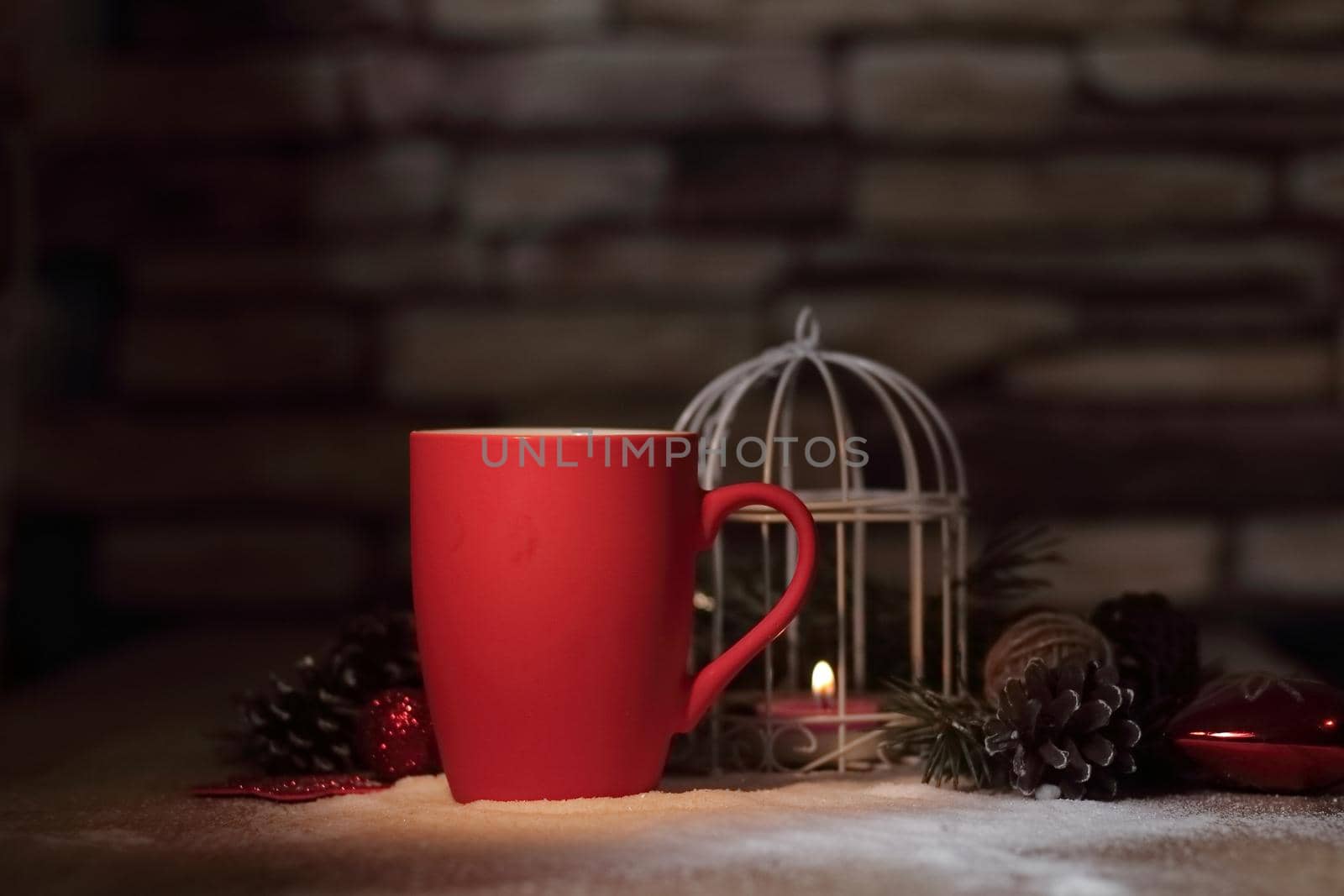 closeup.red Christmas Cup and the candle on the holiday table. photo with copy space.
