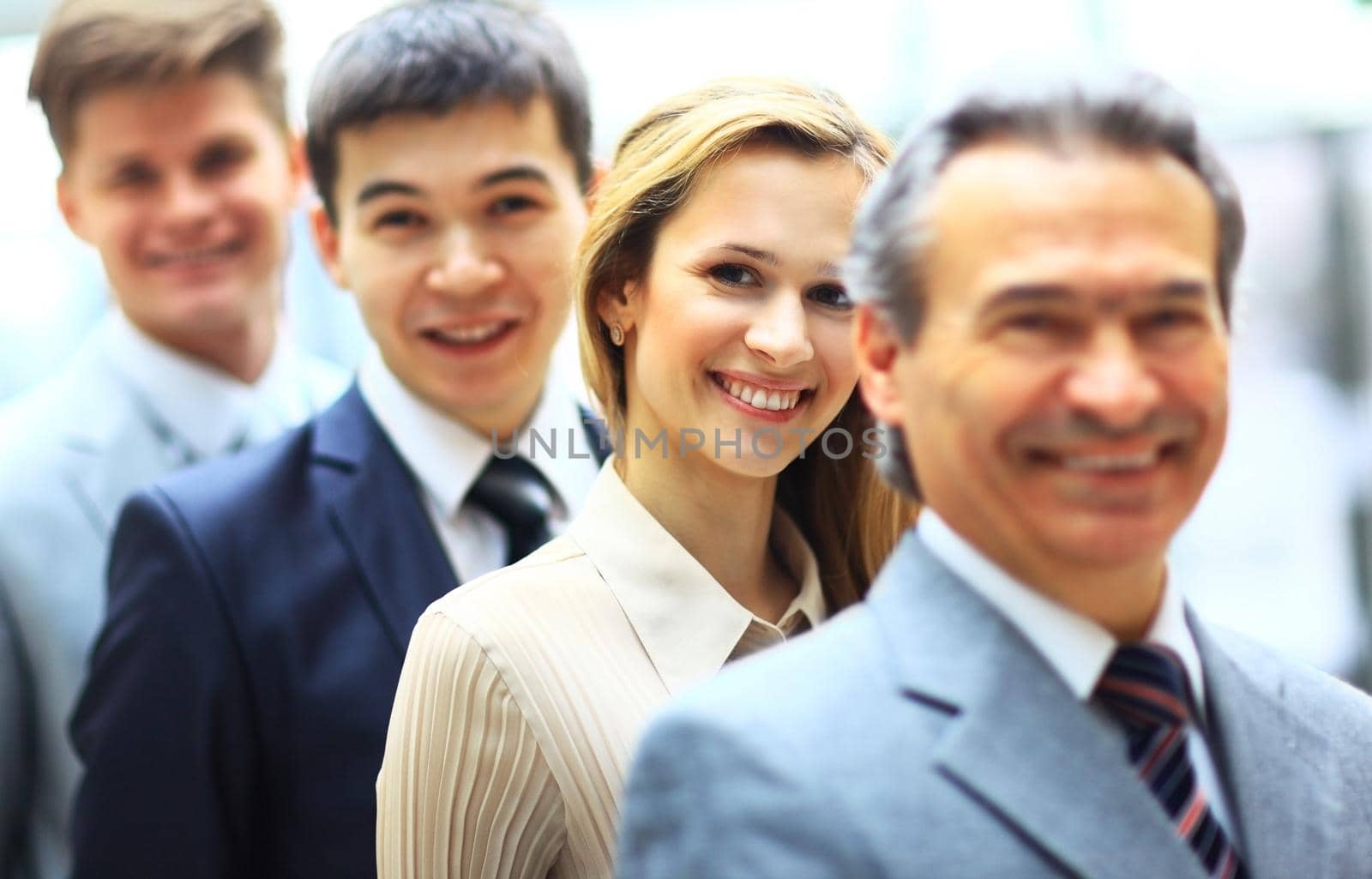 Happy smiling business team standing in a row at office