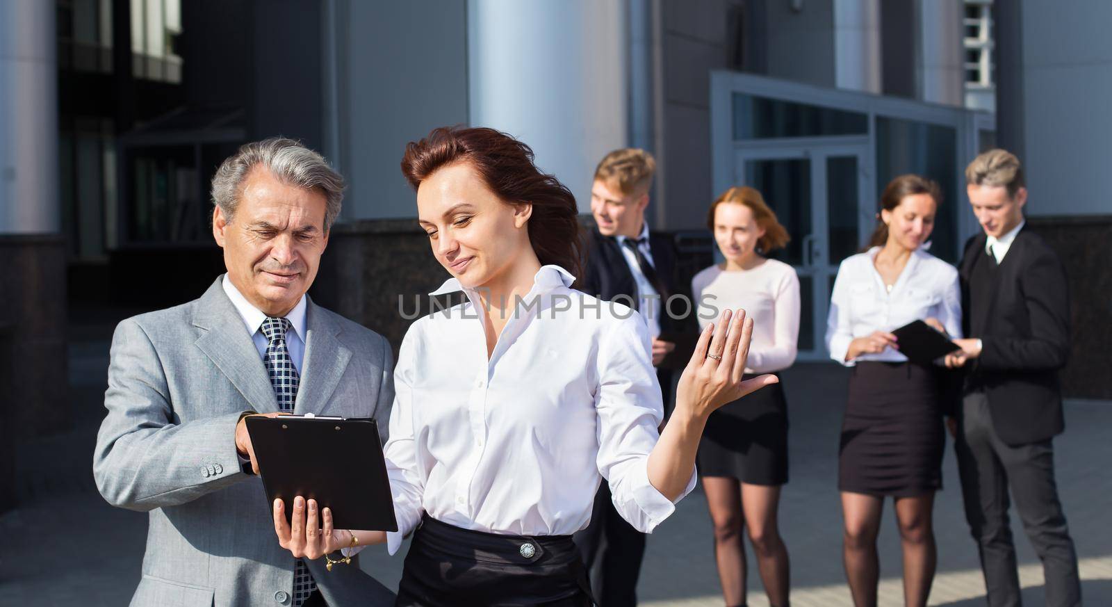 business, technology and office concept - smiling business team with laptop computers and documents having discussion