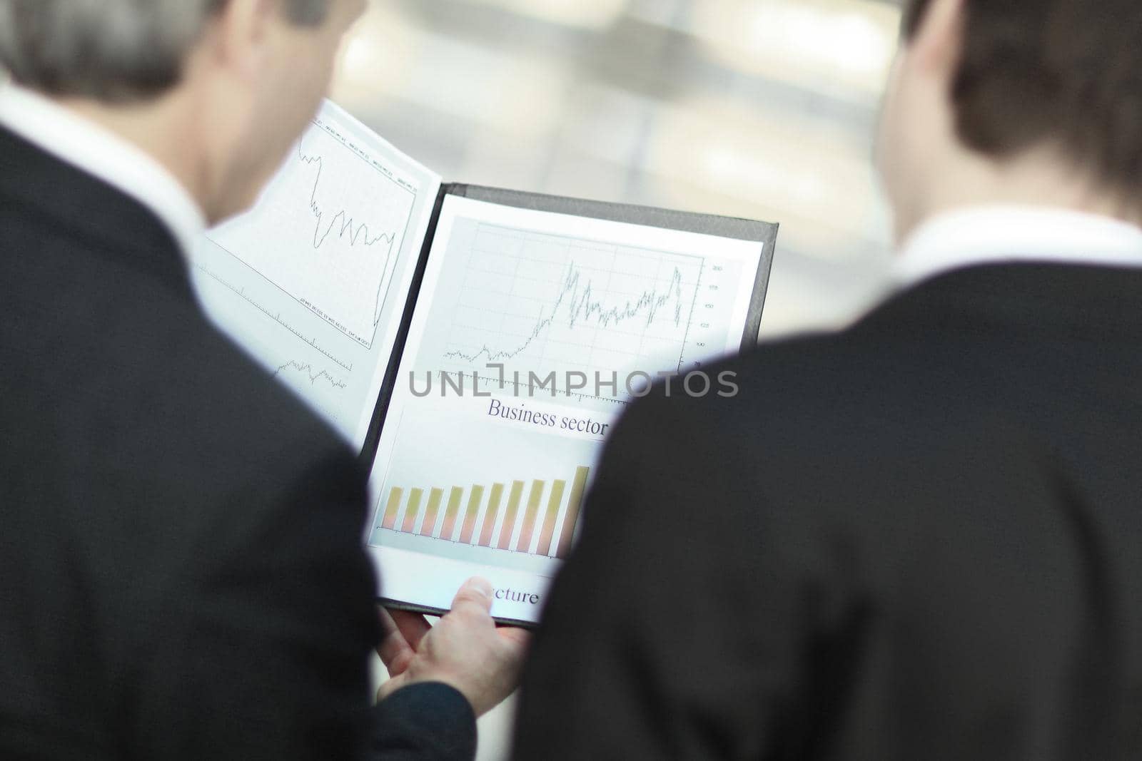 rear view.closeup of business partners discussing financial documents by SmartPhotoLab