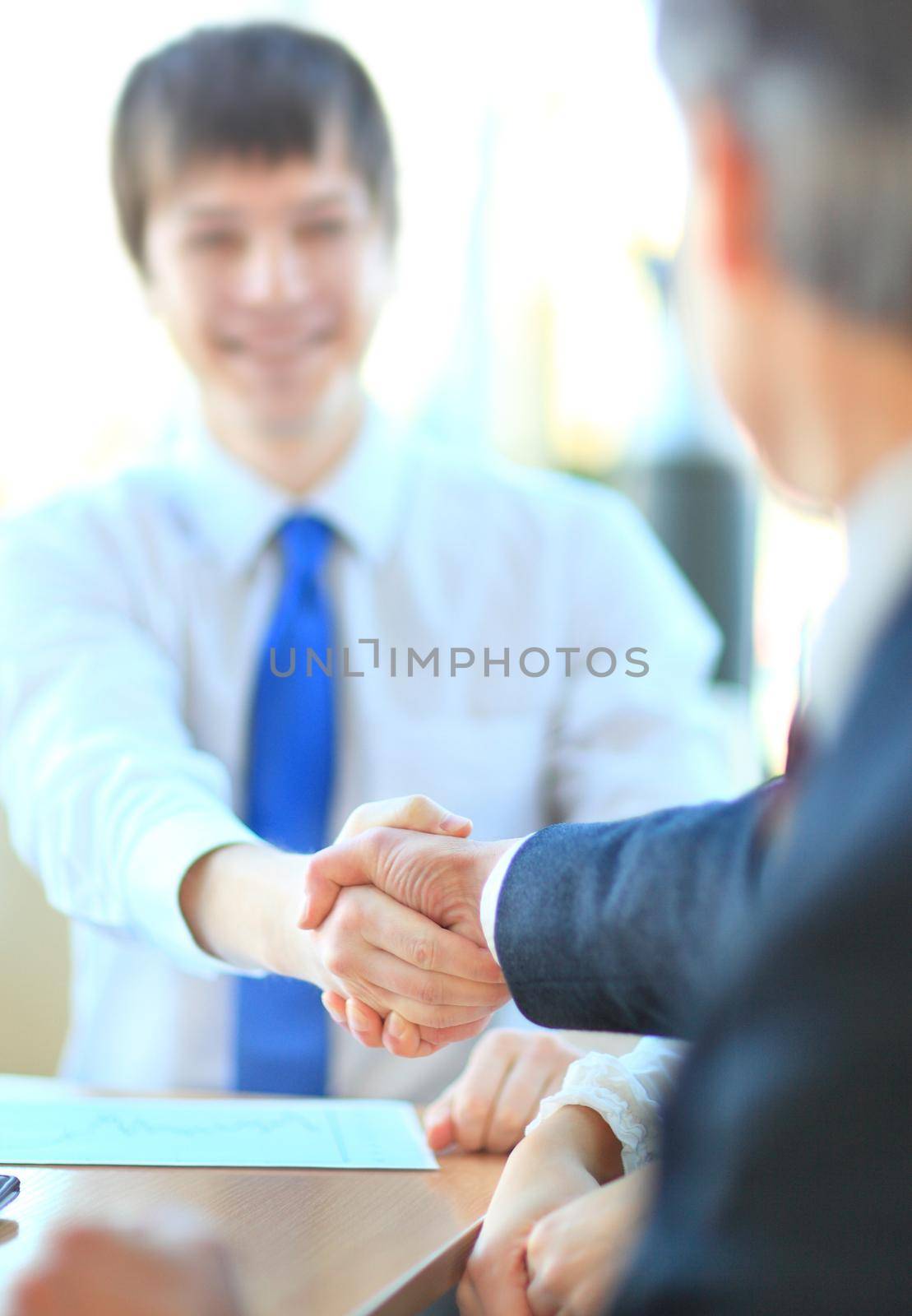 Business people shaking hands, finishing up a meeting by SmartPhotoLab