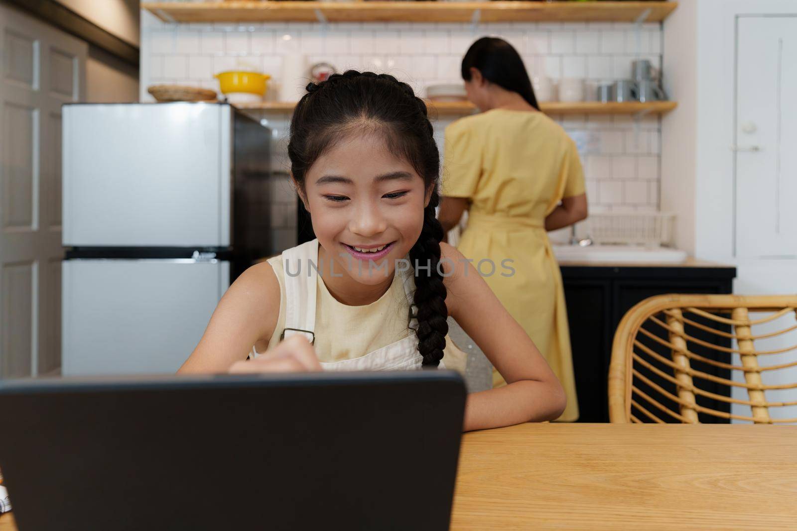Homeschool Asian mother and little young girl student learning online class. E-learning Online Education concept. by itchaznong