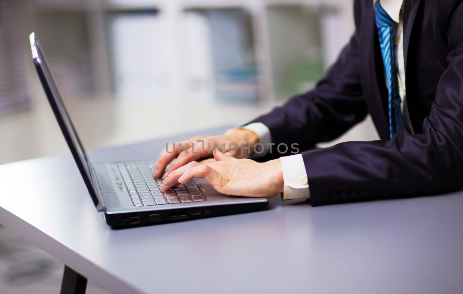 Person Typing on a modern laptop in an office