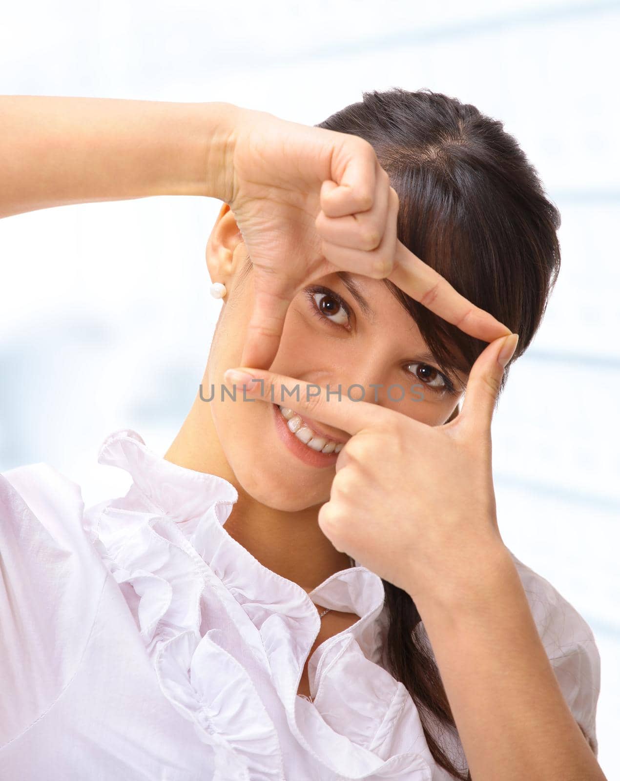 Nice business woman in the office, looking through the window of his fingers. by SmartPhotoLab