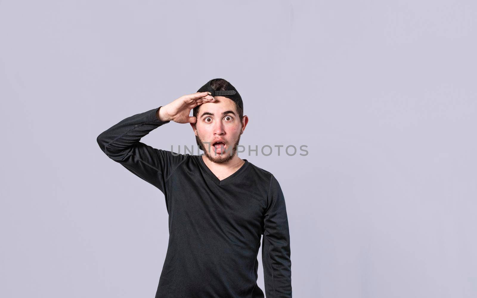 Amazed young man with his mouth open with his hand on his forehead, surprised guy with his mouth open with his hand on his forehead, concept of someone astonished