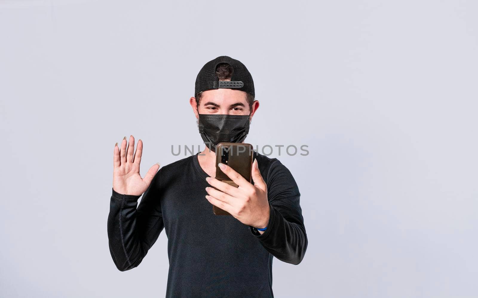 Man making video call isolated, guy making video call with face mask, face mask video call concept by isaiphoto
